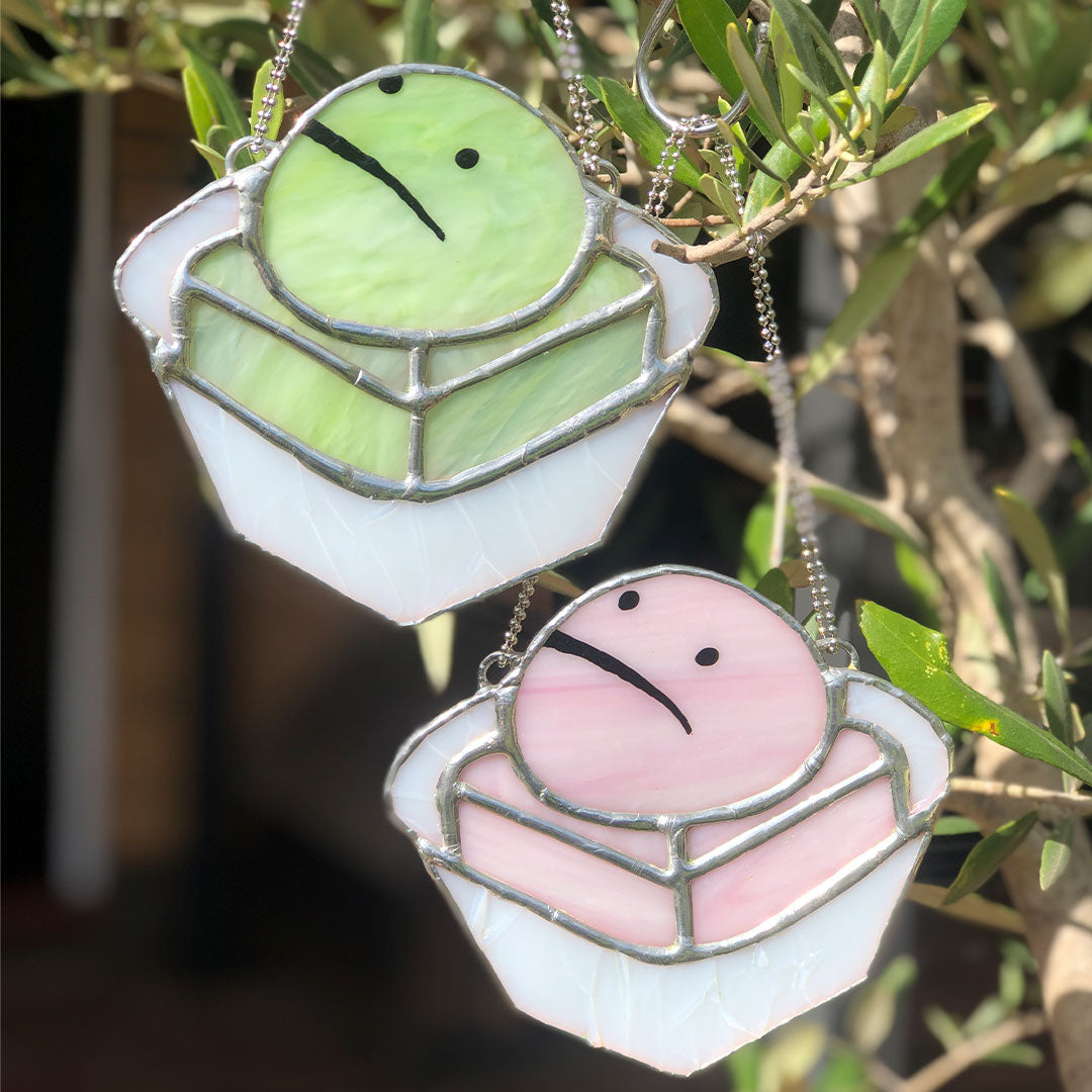 green and pink stained glass frog cakes outside in the sun